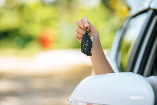 girl-sitting-car-holding-car-keys-hands-out-car